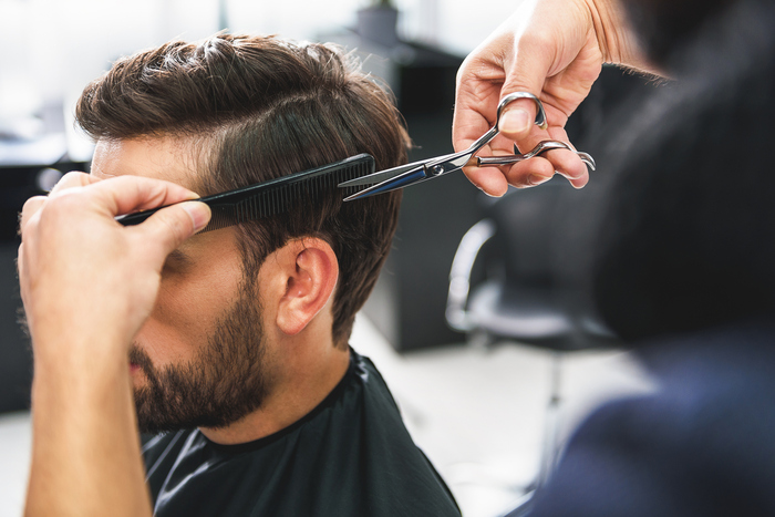 muškarac na šišanju u frizerskom salonu za muškarce
