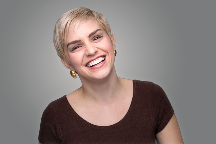 nasmijana žena ima novu kratku frizuru pixie cut i plavu boju kose